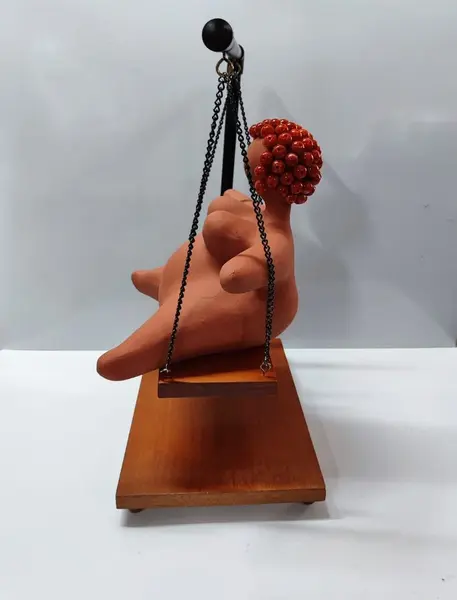 Foto de um(a) Escultura Feminina em Terracota, Peça Única, da categoria de Escultura. Escultura feminina em terracota no balanço, cabelos são de contas na cor coral, balanço em ferro com madeira e base com pés... Mostrado de uma perspectiva diferente. Vendido no marketplace Trésors.