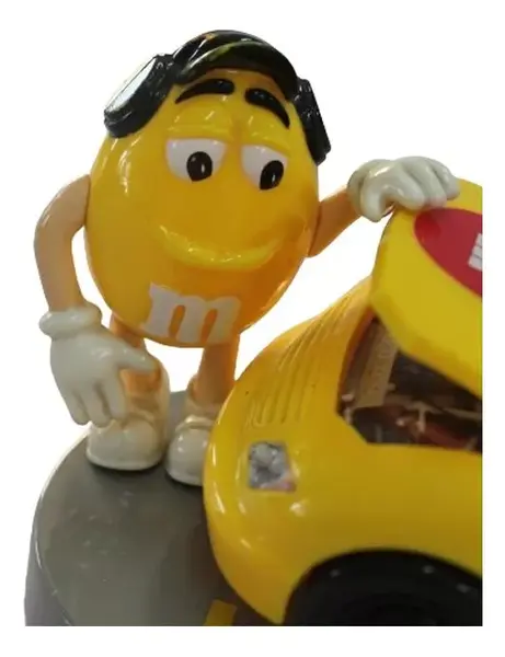 Foto de um(a) Dispenser M & M carro de corrida, da categoria de Brinquedos e Hobbies. Dispenser M&M em formato de carro com dois bonecos em cada lateral, abertura do dispenser fica no teto. Medidas carro 9A x... Mostrado de uma perspectiva diferente. Vendido no marketplace Trésors.