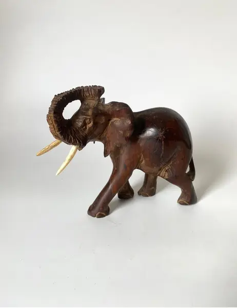 Foto de um(a) Elefante decorativo em madeira, da categoria de Escultura. Elefante decorativo esculpido em madeira. *Contém avaria em uma das orelhas, como mostra a foto. Mede: 17 x 15cm. Mostrado de uma perspectiva diferente. Vendido no marketplace Trésors.