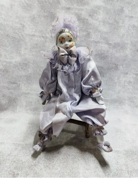 Foto de um(a) Pierrot em Porcelana, Década de 1970, da categoria de Bonecas. Pierrô em porcelana com vestimentas em cetim na cor lilás, corpo em tecido com enchimento e membros móveis. Cabeça com tiara... Mostrado de uma perspectiva diferente. Vendido no marketplace Trésors.