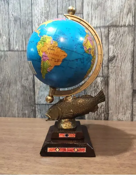 Foto de um(a) Globo Terrestre Peixe Latão Anos 70, da categoria de Globos. Globo terrestre de mesa com globo giratório e envelhecido com base de peixe em latão e madeira com marchetaria adesivada... Mostrado de uma perspectiva diferente. Vendido no marketplace Trésors.