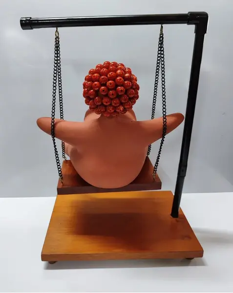 Foto de um(a) Escultura Feminina em Terracota, Peça Única, da categoria de Escultura. Escultura feminina em terracota no balanço, cabelos são de contas na cor coral, balanço em ferro com madeira e base com pés... Mostrado de uma perspectiva diferente. Vendido no marketplace Trésors.
