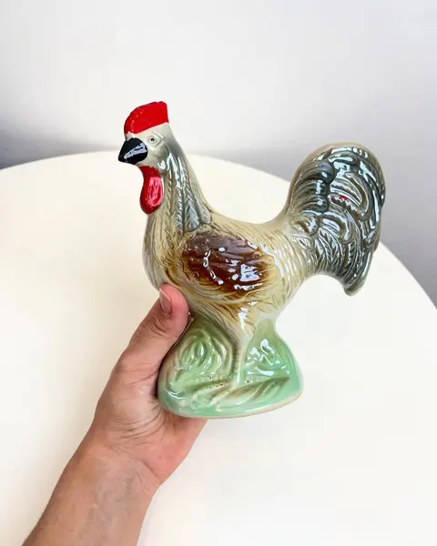 Foto de um(a) Escultura Galo em porcelana, da categoria de Escultura. Galo em porcelana pintada. está praticamente perfeito, apenas com uma marquinha de tinta vermelha no rabo. Mede 17x16cm. Mostrado de uma perspectiva diferente. Vendido no marketplace Trésors.