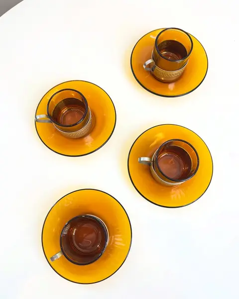 Foto de um(a) Conjunto com 04 xícaras Duralex para café, com suporte em metal, da categoria de Conjuntos de café e chá. Jogo com 4 xícaras e pires Duralex para café. Pontos de oxidação no metal. Mostrado de uma perspectiva diferente. Vendido no marketplace Trésors.