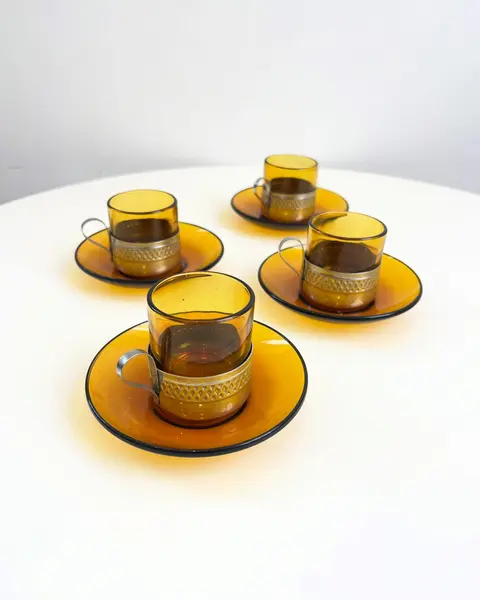 Foto de um(a) Conjunto com 04 xícaras Duralex para café, com suporte em metal, da categoria de Conjuntos de café e chá. Jogo com 4 xícaras e pires Duralex para café. Pontos de oxidação no metal. Mostrado de uma perspectiva diferente. Vendido no marketplace Trésors.