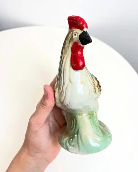 Foto de um(a) Escultura Galo em porcelana, da categoria de Escultura. Galo em porcelana pintada. está praticamente perfeito, apenas com uma marquinha de tinta vermelha no rabo. Mede 17x16cm. Mostrado de uma perspectiva diferente. Vendido no marketplace Trésors.