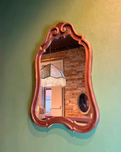 Foto de um(a) Espelho Clássico, da categoria de Espelhos. Moldura esculpida em madeira nobre com leves detalhes entalhados. Mostrado de uma perspectiva diferente. Vendido no marketplace Trésors.