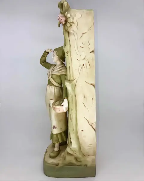Foto de um(a) Antigo Vaso Escultura Em Faiança Royal Dux Art Nouveau, da categoria de Vasos. Antigo e grande vaso, escultura do período Art Nouveau feita à mão em faiança Tcheca, representando jovem camponesa, com... Mostrado de uma perspectiva diferente. Vendido no marketplace Trésors.