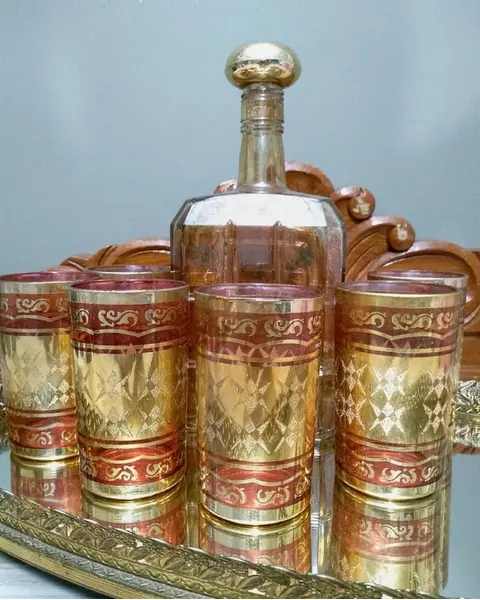 Foto de um(a) Conjunto Indiano Anos 70, da categoria de Jogos de taças e copos. Conjunto indiano e folheado a ouro, 6 copos em vidro (made in korea) e 1 garrafa em cristal âmbar com pintura floral para... Mostrado de uma perspectiva diferente. Vendido no marketplace Trésors.