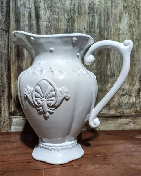 Foto de um(a) Jarra em porcelana, da categoria de Garrafas, potes e jarros. Jarra em porcelana com detalhes em relevo. A: 26cm Diâmetro: 25cm Peso: 1,250kg. Mostrado de uma perspectiva diferente. Vendido no marketplace Trésors.