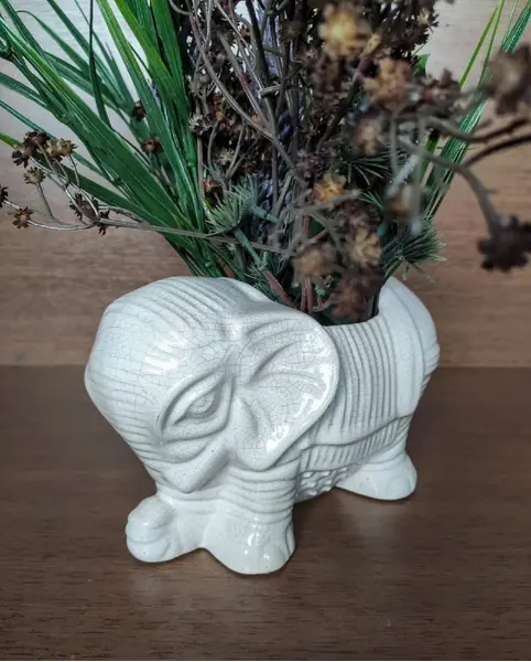 Foto de um(a) Cachepô Elefante Anos 90, da categoria de Cachepot. Cachepô formato de elefante em porcelana craquelada na cor branca, década de 1990. A: 12,5 cm / L: 20cm / P: 12 cmPeso: 704g. Mostrado de uma perspectiva diferente. Vendido no marketplace Trésors.