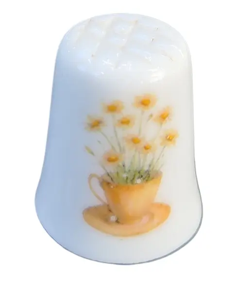 Foto de um(a) Dedal de Coleção em Porcelana – Tema Camomila e Abelha no Campo, da categoria de Outros colecionáveis. O design destaca-se pela composição harmoniosa: de um lado, um gracioso arranjo de camomilas (margaridas) brotando de uma... Vendido no marketplace Trésors.
