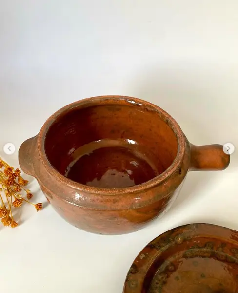 Foto de um(a) Panela de barro, da categoria de Panelas. Panela de barro. 19 cm de diâmetro e 11 cm de altura *contém um bicado na pega. Mostrado de uma perspectiva diferente. Vendido no marketplace Trésors.