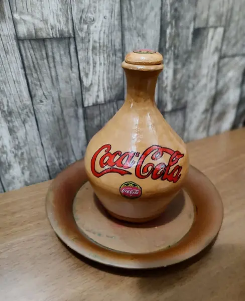 Foto de um(a) Moringa Coca-Cola, da categoria de Garrafas, potes e jarros. Coca cola raíz é outra coisa! Direto do sul de minas gerais, uma velha moringa de barro personalizada. Peça única pelo... Mostrado de uma perspectiva diferente. Vendido no marketplace Trésors.