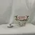 Foto de um(a) Vaso em Porcelana Branco com Pinturas de Rosas, da categoria de Vasos. Vaso em porcelana de coloração branca, com detalhes em rosa e dourado. Pintura representando flores. Mostrado de uma perspectiva diferente. Vendido no marketplace Trésors.