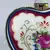 Foto de um(a) Porta-jóias em formato de coração, da categoria de Porta-Jóias. Porta-jóias em porcelana branca no formato de coração com flores em policromia e metal dourado. Mede 7cm de diâmetro,... Mostrado de uma perspectiva diferente. Vendido no marketplace Trésors.