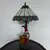 Foto de um(a) Abajur estilo Tiffany com escultura de palhaço, da categoria de Abajures. Bellisimo abajur estilo Tiffany com escultura de palhaço lendo livro. Medidas: altura 48 cm x diâmetro cúpula 28 cm x base... Mostrado de uma perspectiva diferente. Vendido no marketplace Trésors.