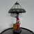 Foto de um(a) Abajur estilo Tiffany com escultura de palhaço, da categoria de Abajures. Bellisimo abajur estilo Tiffany com escultura de palhaço lendo livro. Medidas: altura 48 cm x diâmetro cúpula 28 cm x base... Mostrado de uma perspectiva diferente. Vendido no marketplace Trésors.