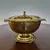 Foto de um(a) Antigo centro de mesa/bomboniere em metal, da categoria de Centro de mesa. Antigo centro de mesa / bomboniere em metal vazado dourado. Medidas : diâmetro 23 cm x altura 14 cm. Mostrado de uma perspectiva diferente. Vendido no marketplace Trésors.