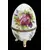 Foto de um(a) Ovo Fabergé em porcelana Limoges, da categoria de Objetos decorativos. Charmoso ovo Fabergé com decoração de flores pintado à mão em policromia, com acabamento em metal dourado, assente em tripé... Mostrado de uma perspectiva diferente. Vendido no marketplace Trésors.