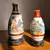Foto de um(a) Antigo Par De Pequenos Vasos Orientais Porcelana Japonesa, da categoria de Vasos. Antigo par de vasinhos orientais em porcelana japonesa, pintados à mão. Base em madeira de lei. Altura 14 e 17cm. Mostrado de uma perspectiva diferente. Vendido no marketplace Trésors.