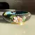 Foto de um(a) Antigo Trio De Cinzeiros Orientais Em Bronze Cloisonné, da categoria de Cinzeiros. Antigos e lindos cinzeiros orientais feitos à mão em Cloisonné. Decorados com flores e folhagens, com esmalte azul na parte... Mostrado de uma perspectiva diferente. Vendido no marketplace Trésors.