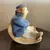 Foto de um(a) Antigo Bibelô De Coleção Art Deco Porcelana Alemã, da categoria de Escultura. Bibelô em porcelana alemã, representando senhor que balança na cadeira, período Art Deco. Década de 1940.Medidas 12x12xcm. Mostrado de uma perspectiva diferente. Vendido no marketplace Trésors.