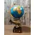 Foto de um(a) Globo Terrestre Latão e Marchetaria anos 70, da categoria de Globos. Globo terrestre de mesa com globo giratório e envelhecido com base de peixe em latão e madeira com marchetaria adesivada... Mostrado de uma perspectiva diferente. Vendido no marketplace Trésors.