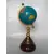 Foto de um(a) Globo Torneado, da categoria de Globos. Globo terrestre com base em madeira torneada e latão e haste dourada. A: 26cm D globo: 10cm D base: 10cm. Mostrado de uma perspectiva diferente. Vendido no marketplace Trésors.