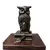 Foto de um(a) Coruja Bronze Anos 80, da categoria de Escultura. Coruja em broze com base em imbuia. A: 12,7 cm / L: 5,6 cm / P: 5,6 cm Base: 12,5 x 10 x 1,5 cm Peso: 521 g. Vendido no marketplace Trésors.