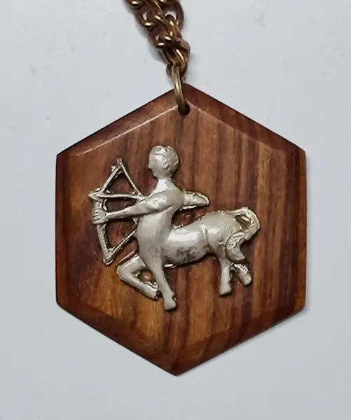Foto de um(a) Colar em Jacarandá com Medalhão Signo de Sagitário, Década de 1970, da categoria de Outros colecionáveis. Colar de madeira de jacarandá dos anos 1970: corrente com 14 retângulos com base quadrada, unidos por corrente dourada... Mostrado de uma perspectiva diferente. Vendido no marketplace Trésors.