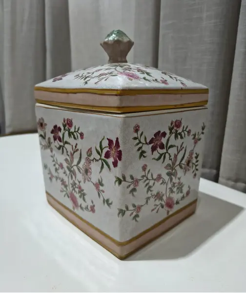 Foto de um(a) Antigo Pote Decorativo em Faiança com Tampa Floral, da categoria de Garrafas, potes e jarros. Produzido em porcelana/faiança de excelente espessura, a peça apresenta formato retangular e uma belíssima pintura botânica... Mostrado de uma perspectiva diferente. Vendido no marketplace Trésors.