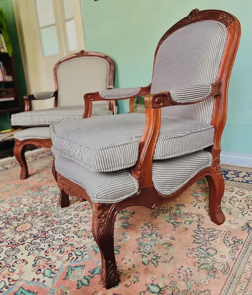 Foto de um(a) Par de Poltronas Luís XV em Madeira entalhada com estofado listrado, da categoria de Poltronas. Par de poltronas em madeira nobre, entalhadas com motivos florais, assento encosto e apoio dos braços estofados, totalmente... Mostrado de uma perspectiva diferente. Vendido no marketplace Trésors.