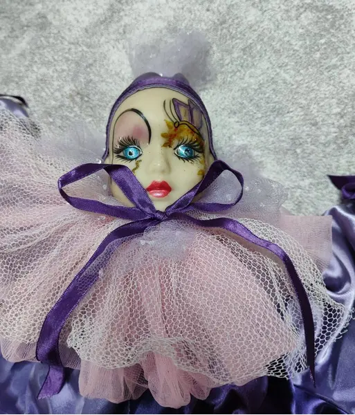 Foto de um(a) Pierrot em Resina, Década de 1980, da categoria de Modelos e estatuetas. Pierrô em resina com roupa em cetim roxo e lilás, gola de tule rosa, lilás e branco. Corpo em tecido com enchimento, década... Mostrado de uma perspectiva diferente. Vendido no marketplace Trésors.
