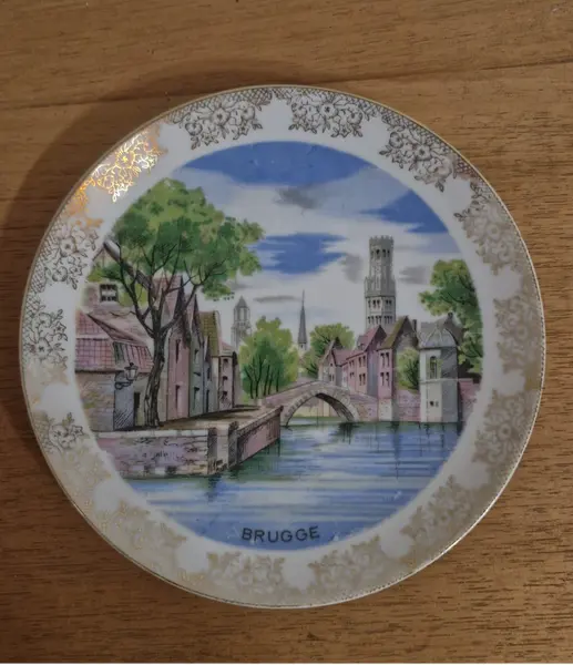 Foto de um(a) Lindo prato de coleção em porcelana, da categoria de Pratos Decorativos. Lindíssimo prato em porcelana, que apresenta uma pintura cênica de Bruges, na Bélgica, destacando um de seus famosos canais... Mostrado de uma perspectiva diferente. Vendido no marketplace Trésors.