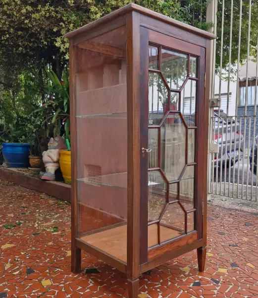 Foto de um(a) Cristaleira vitrine antiga em madeira maciça, da categoria de Cristaleiras. Belíssima e elegante cristaleira vitrine antiga, confeccionada em madeira de lei maciça com tonalidade escura e veios... Mostrado de uma perspectiva diferente. Vendido no marketplace Trésors.