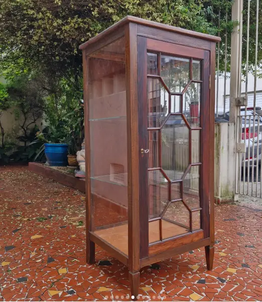 Foto de um(a) Cristaleira vitrine antiga em madeira maciça, da categoria de Cristaleiras. Belíssima e elegante cristaleira vitrine antiga, confeccionada em madeira de lei maciça com tonalidade escura e veios... Mostrado de uma perspectiva diferente. Vendido no marketplace Trésors.