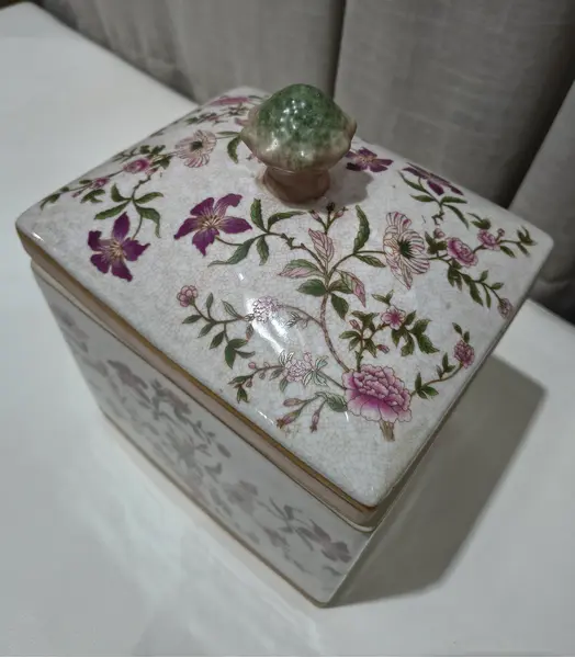 Foto de um(a) Antigo Pote Decorativo em Faiança com Tampa Floral, da categoria de Garrafas, potes e jarros. Produzido em porcelana/faiança de excelente espessura, a peça apresenta formato retangular e uma belíssima pintura botânica... Mostrado de uma perspectiva diferente. Vendido no marketplace Trésors.