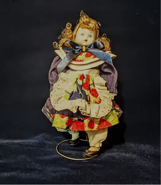 Foto de um(a) Boneca Porcelana e Tecido, Per Bambino, Década de 1990, da categoria de Bonecas. Boneca com membros e cabeça em porcelana, corpo em tecido/enchimento. Vestido original, cabelos de vinil e acompanha suporte... Mostrado de uma perspectiva diferente. Vendido no marketplace Trésors.