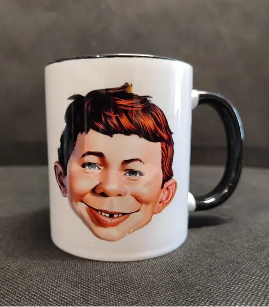 Foto de um(a) Caneca Bom Alfredo, Alfred E. Neuman da Revista Mad, da categoria de Canecas. Caneca alfred e. Neuman da revista mad: um clássico que marcou época. Teve seu início em 1954. Caneca em porcelana com alça... Mostrado de uma perspectiva diferente. Vendido no marketplace Trésors.