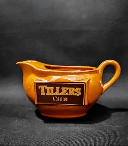 Foto de um(a) Molheira Escocesa Tillers Club, Década de 1980, da categoria de Cremeiras. Molheira com logo da tillers club dos anos 1980 em porcelana na cor âmbar.A: 10 cm L: 15,5 cm L com alça: 19,4 cm P: 9 cm... Mostrado de uma perspectiva diferente. Vendido no marketplace Trésors.