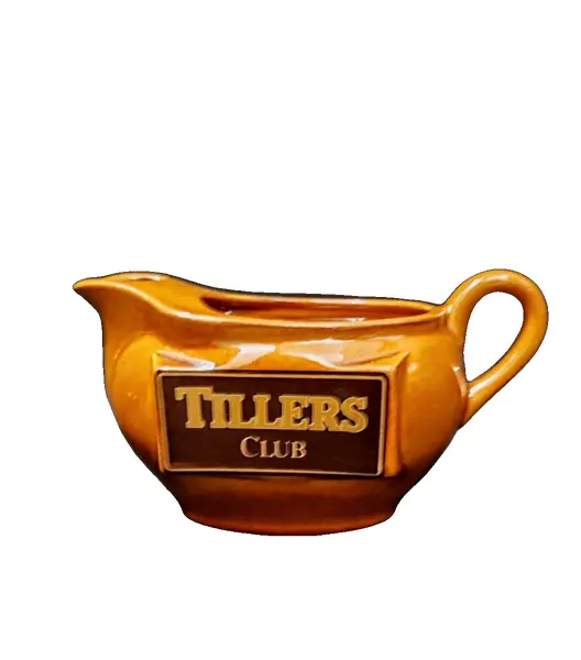 Foto de um(a) Molheira Escocesa Tillers Club, Década de 1980, da categoria de Cremeiras. Molheira com logo da tillers club dos anos 1980 em porcelana na cor âmbar.A: 10 cm L: 15,5 cm L com alça: 19,4 cm P: 9 cm... Vendido no marketplace Trésors.