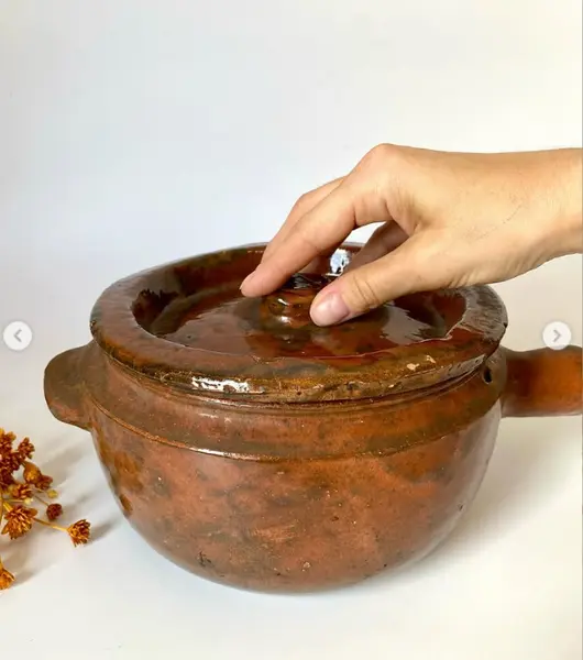 Foto de um(a) Panela de barro, da categoria de Panelas. Panela de barro. 19 cm de diâmetro e 11 cm de altura *contém um bicado na pega. Mostrado de uma perspectiva diferente. Vendido no marketplace Trésors.