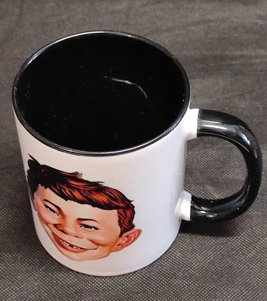 Foto de um(a) Caneca Bom Alfredo, Alfred E. Neuman da Revista Mad, da categoria de Canecas. Caneca alfred e. Neuman da revista mad: um clássico que marcou época. Teve seu início em 1954. Caneca em porcelana com alça... Mostrado de uma perspectiva diferente. Vendido no marketplace Trésors.