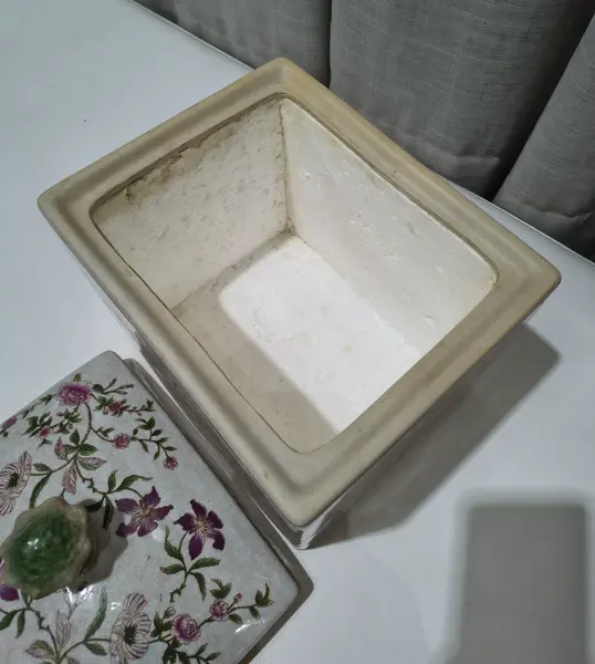 Foto de um(a) Antigo Pote Decorativo em Faiança com Tampa Floral, da categoria de Garrafas, potes e jarros. Produzido em porcelana/faiança de excelente espessura, a peça apresenta formato retangular e uma belíssima pintura botânica... Mostrado de uma perspectiva diferente. Vendido no marketplace Trésors.