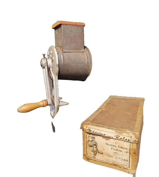 Foto de um(a) Ralador de Queijo e Frutas, Marca Yara N.200, Década de 1940, da categoria de Acessórios de cozinha. Máquina de ralar queijo, coco e frutas. Em ferro, folha de flanders e socador e manivela em madeira, com embalagem original... Vendido no marketplace Trésors.