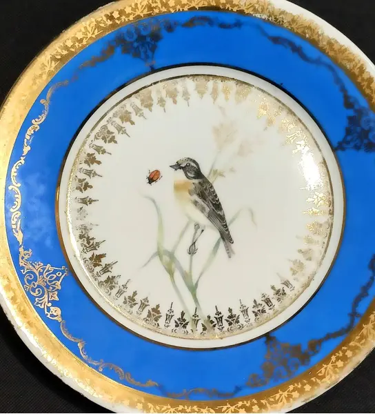 Foto de um(a) Prato Porcelana Dom Pedro, Rio de Janeiro, Década de 1940, da categoria de Pratos Decorativos. Prato de parede policromado e filetado e arabescos em toda a borda. Parte interna com pintura de um passarinho sobre ramos.... Mostrado de uma perspectiva diferente. Vendido no marketplace Trésors.