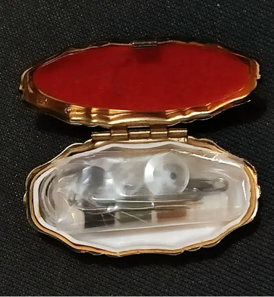 Foto de um(a) Costureiro de Bolsa Anos 80, da categoria de Outros colecionáveis. Costureiro de bolsa em caixa de metal dourado com tampa em acrílico policromado. Compondo o kit com material de costura de... Mostrado de uma perspectiva diferente. Vendido no marketplace Trésors.