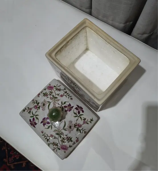 Foto de um(a) Antigo Pote Decorativo em Faiança com Tampa Floral, da categoria de Garrafas, potes e jarros. Produzido em porcelana/faiança de excelente espessura, a peça apresenta formato retangular e uma belíssima pintura botânica... Mostrado de uma perspectiva diferente. Vendido no marketplace Trésors.