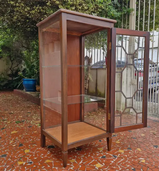 Foto de um(a) Cristaleira vitrine antiga em madeira maciça, da categoria de Cristaleiras. Belíssima e elegante cristaleira vitrine antiga, confeccionada em madeira de lei maciça com tonalidade escura e veios... Mostrado de uma perspectiva diferente. Vendido no marketplace Trésors.